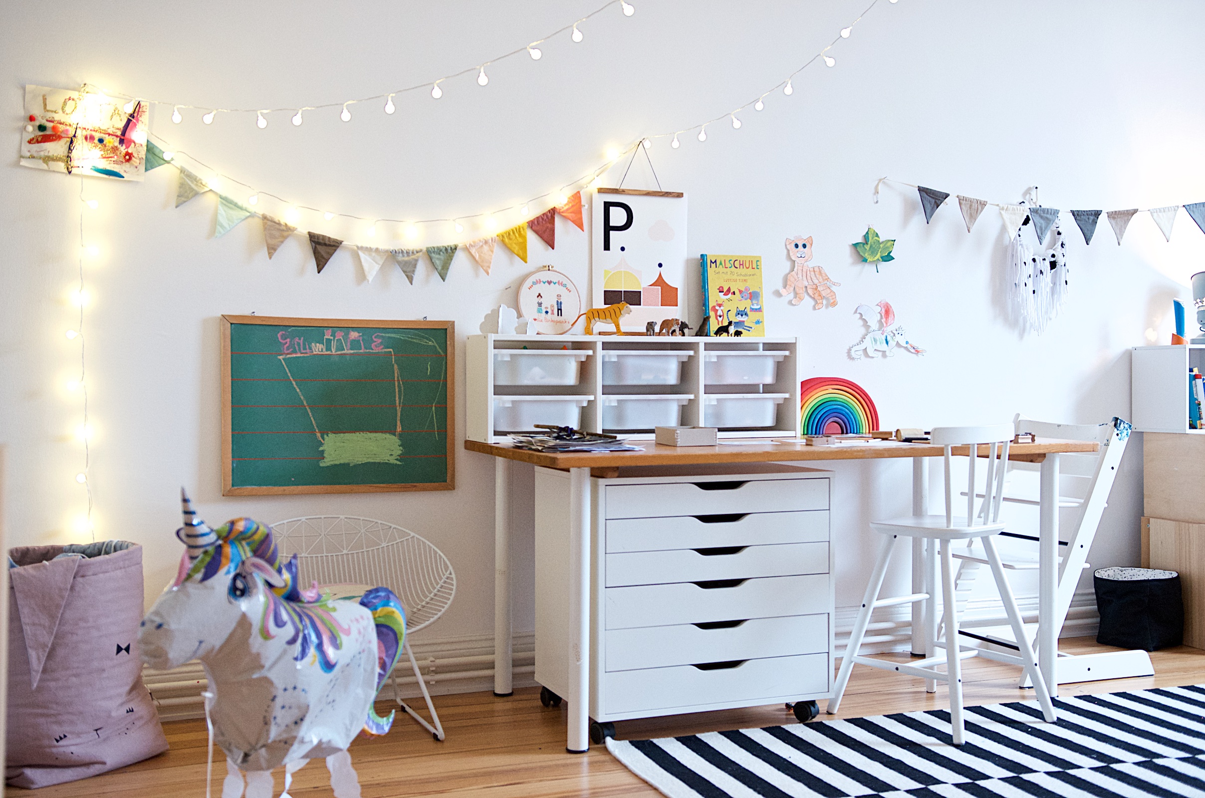 Kreativ-Ecke im Kinderzimmer mit Schreibtisch, Schubladenelement und Lichterketten