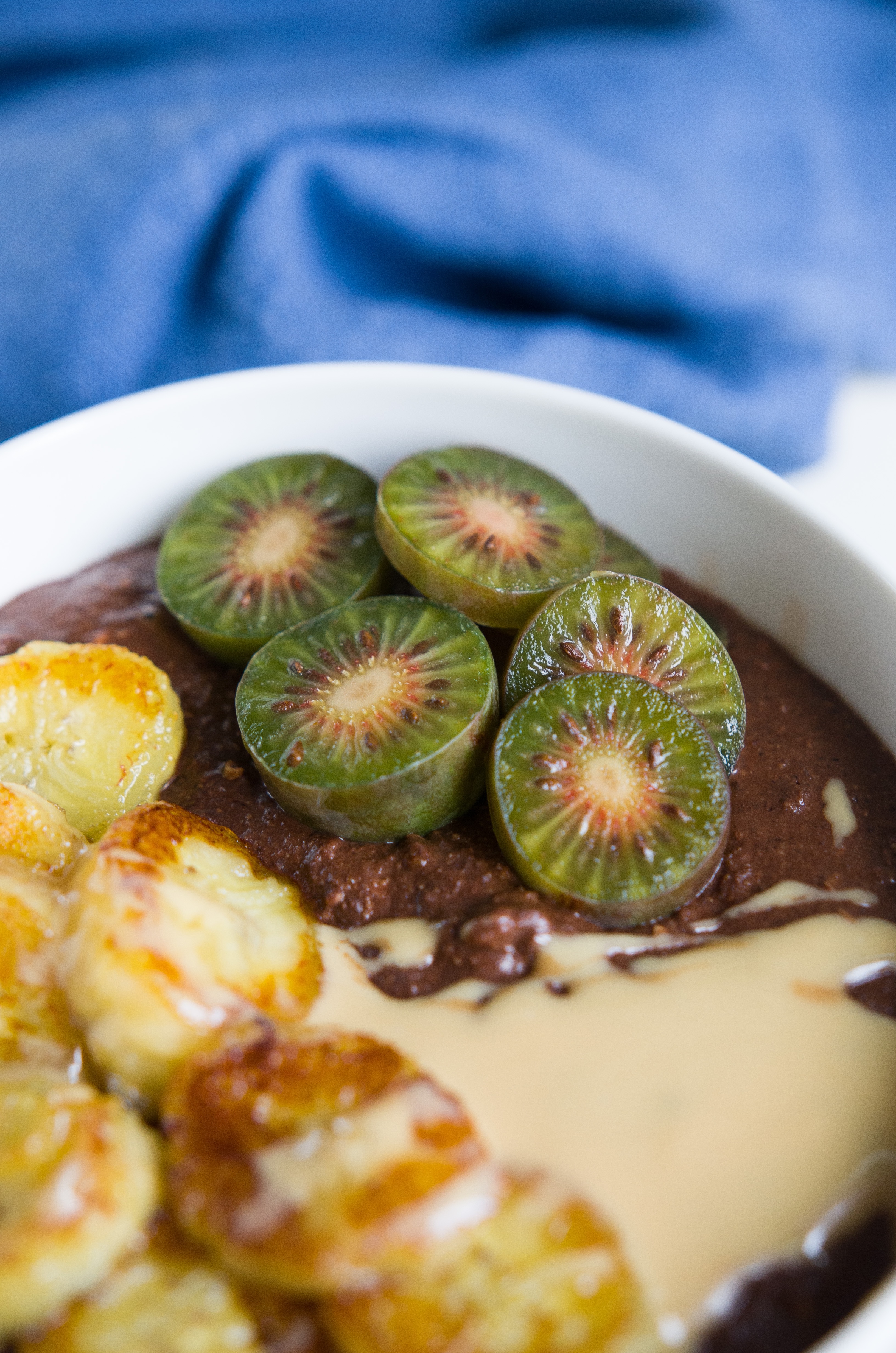 Smoothie Bowl mit Banane, Erdnussmus und Mini-Kiwi. Leckeres und gesundes Frühstück.