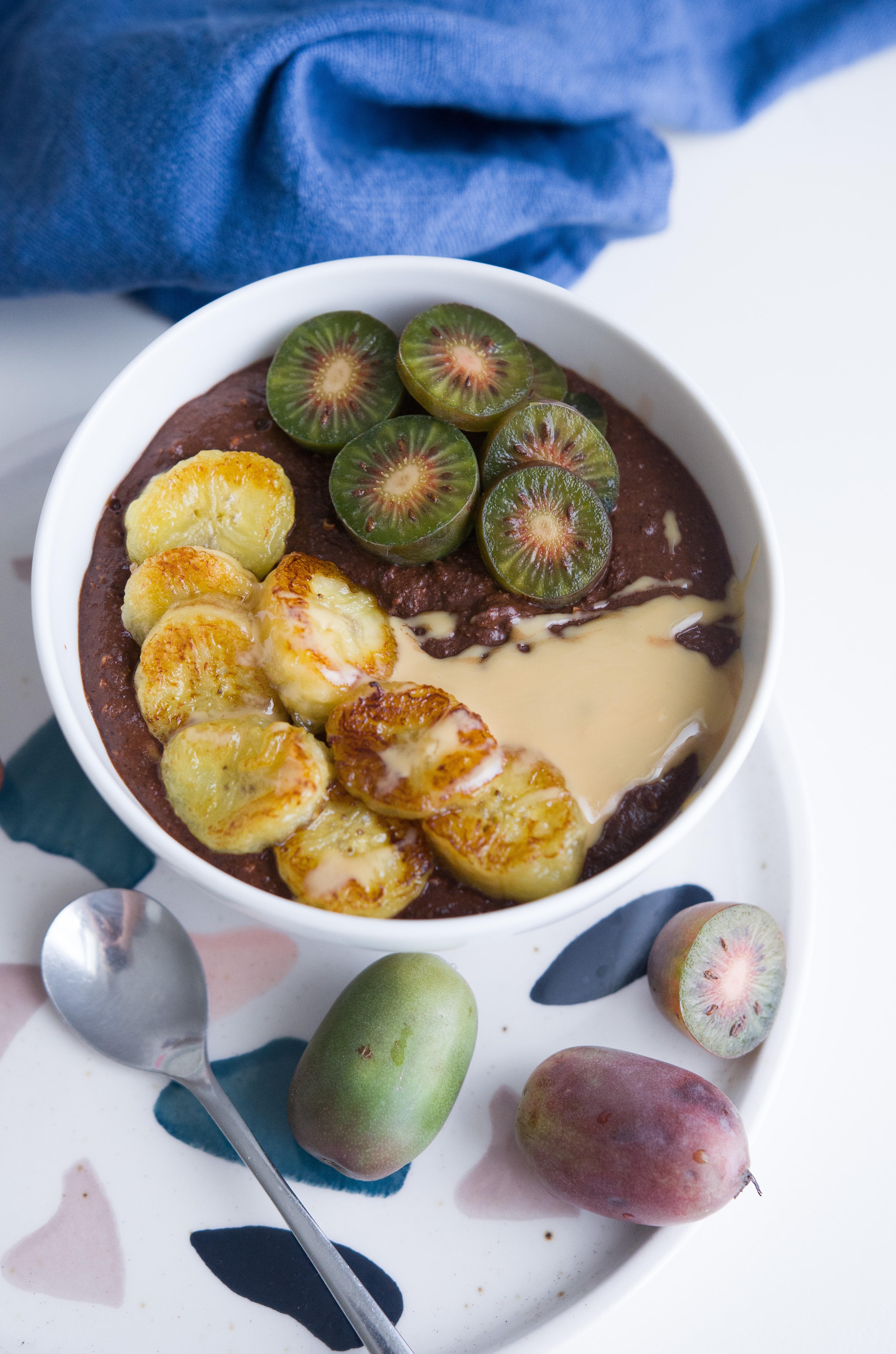 Smoothie Bowl mit Banane, Erdnussmus und Mini-Kiwi. Leckeres und gesundes Frühstück.